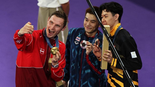 Viktor Axelsen memamerkan dua medali emas miliknya yang diraih dalam dua edisi Olimpiade yang berbeda