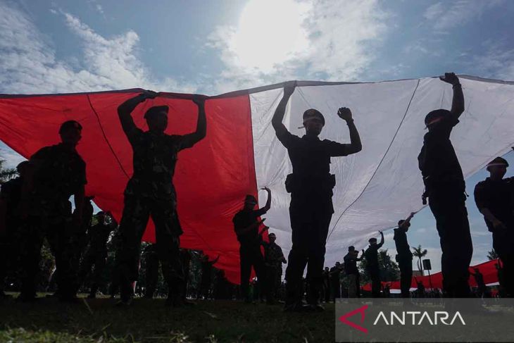 Sejumlah anggota TNI dan polisi membawa Bendera Merah Putih berukuran 50x5 meter saat apel dan Kirab Kebangsaan Merah Putih di Kota Pekalongan Jawa Tengah